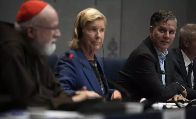 Clergy sex abuse survivor and victim's advocate Juan Carlos Cruz, right, listens to Cardinal Sean Patrick O' Malley speaking during a press conference to present the Vatican's first Annual Global Report on Minors Protection at the Vatican press center, Tuesday, Oct. 29, 2024. (AP Photo/Alessandra Tarantino)