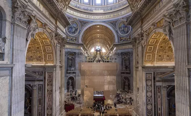 Experts show to journalists, Tuesday, Oct. 8, 2024, the end of the restoration works of Bernini's monumental bronze canopy, situated beneath Michelangelo's massive dome after the gleaming bronze of its twisting Solomonic columns has been concealed by scaffolds for nine months while expert conservators worked meticulously on its intricate surface. (AP Photo/Domenico Stinellis)