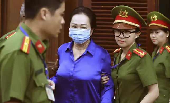 Vietnamese real estate tycoon Truong My Lan, center, is escorted to a trial for her verdict on fraud, money laundering and illegal cross-border money transferring in Ho Chi Minh city, Vietnam Thursday, Oct. 17, 2024. (Quynh Tran/VNExpress via AP)