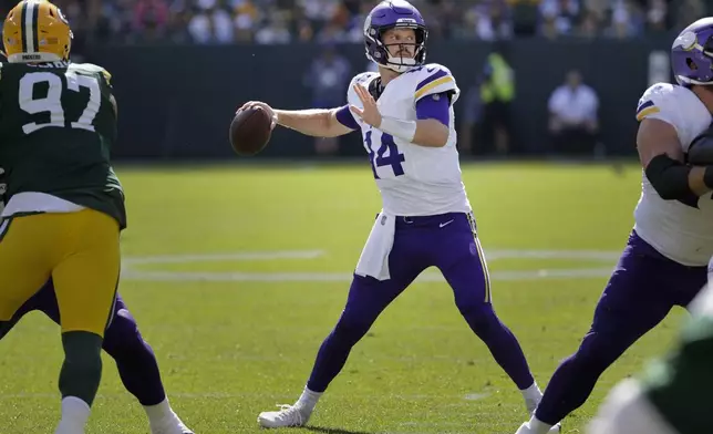 Minnesota Vikings quarterback Sam Darnold (14) looks to throw a pass during the first half of an NFL football game against the Green Bay Packers, Sunday, Sept. 29, 2024, in Green Bay, Wis. (AP Photo/Mike Roemer)