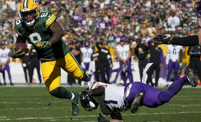 Green Bay Packers running back Josh Jacobs (8) is tackled by Minnesota Vikings linebacker Blake Cashman, right, during the second half of an NFL football game Sunday, Sept. 29, 2024, in Green Bay, Wis. (AP Photo/Morry Gash)