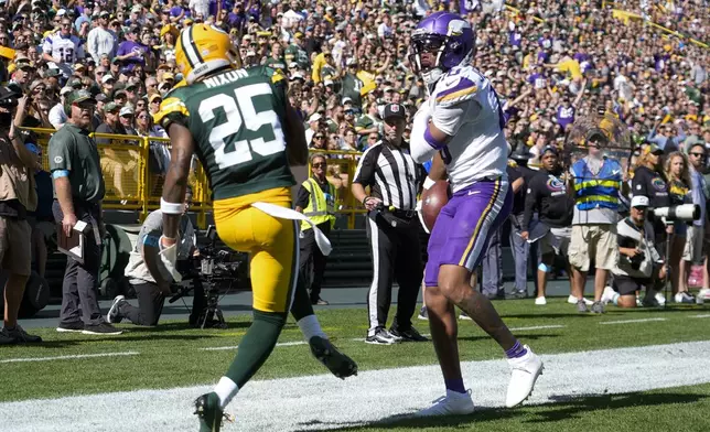 Minnesota Vikings wide receiver Justin Jefferson, right, scores a touchdown past Green Bay Packers cornerback Keisean Nixon (25) during the first half of an NFL football game Sunday, Sept. 29, 2024, in Green Bay, Wis. (AP Photo/Morry Gash)