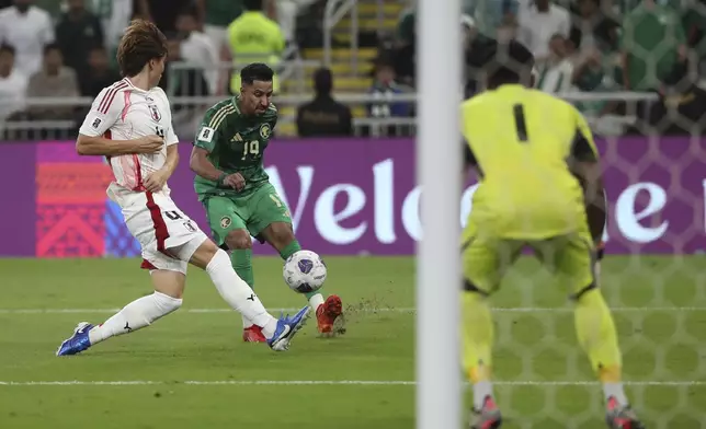 Saudi Arabia's Salem Al Dawsari, center, plays the ball as Japan's Kou Itakura defends during 2026 World Cup qualifying soccer game, Thursday, Oct. 10, 2024, at the King Abdullah Sports City in Jeddah, Saudi Arabia. (AP Photo)