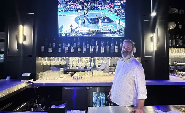 Josh Pehlke works the bar at Signature Bar &amp; Restaurant in Chicago’s South Loop neighborhood near the Chicago Sky’s home at Wintrust Arena sit at the bar as Game 2 of the WNBA finals between the New York Liberty and Minnesota Lynx is shown on a TV on Sunday, Oct. 13, 2024. Pehlke, Signature's general manager, says the restaurant is getting more requests for TVs tuned to the WNBA. (AP Photo/Andrew Seligman)