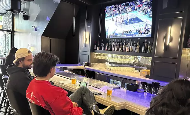 Customers at Signature Bar &amp; Restaurant in Chicago’s South Loop neighborhood near the Chicago Sky’s home at Wintrust Arena sit at the bar as Game 2 of the WNBA finals between the New York Liberty and Minnesota Lynx is shown on a TV on Sunday, Oct. 13, 2024. The WNBA drew sellout crowds and unprecedented ratings in a transformational season. Sports-oriented bars and restaurants are taking note. Some say they’re seeing an increased demand for women’s sports on their TVs. (AP Photo/Andrew Seligman)