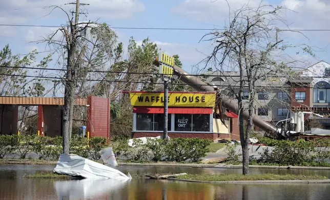 FILE - A billboard lies atop a Waffle House restaurant after being knocked down by Hurricane Michael in Panama City, Fla., Oct. 14, 2018. (Carlos R. Munoz/Sarasota Herald-Tribune via AP, File)