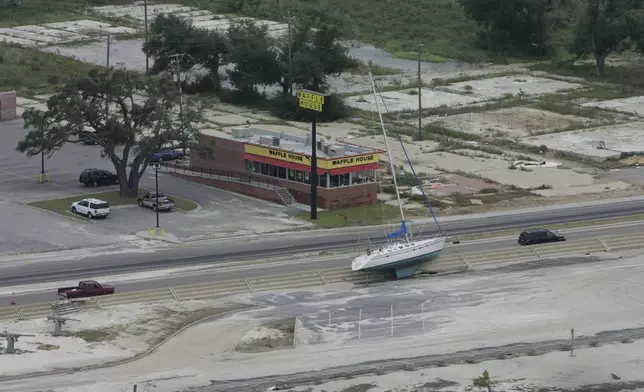 FILE - A sailboat washed out of the water during Hurricane Gustav. rests next to a road in Biloxi, Miss., Sept. 3, 2008. (AP Photo/James Edward Bates/Sun Herald, File)