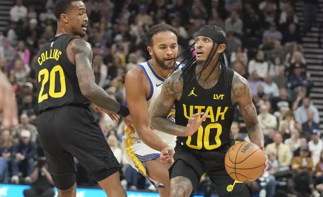 Utah Jazz forward John Collins (20) sets a screen against Golden State Warriors forward Kyle Anderson, center, who defends against Jazz guard Jordan Clarkson (00) in the first half of an NBA basketball game Friday, Oct. 25, 2024, in Salt Lake City. (AP Photo/George Frey)