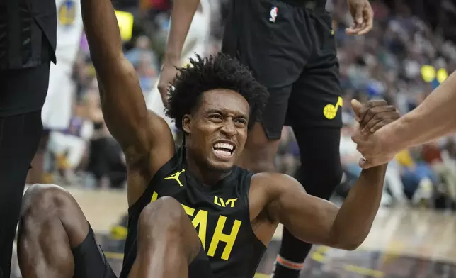 Utah Jazz guard Collin Sexton is helped up after falling in the first half of an NBA basketball game against Golden State Warriors, Friday, Oct. 25, 2024, in Salt Lake City. (AP Photo/George Frey)