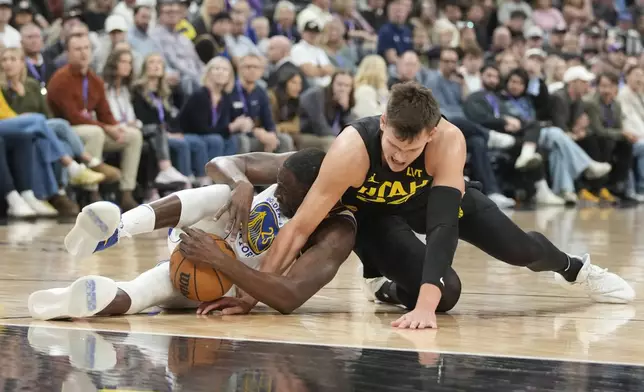 Utah Jazz center Walker Kessler (24) fights fro the ball with Golden State Warriors forward Draymond Green (23) in the first half of an NBA basketball game Friday, Oct. 25, 2024, in Salt Lake City. (AP Photo/George Frey)