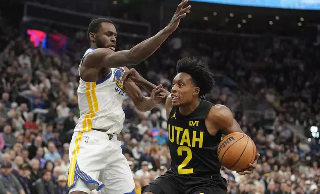 Golden State Warriors forward Andrew Wiggins, left, defends against Utah Jazz guard Collin Sexton (2) in the first half of an NBA basketball game Friday, Oct. 25, 2024, in Salt Lake City. (AP Photo/George Frey)