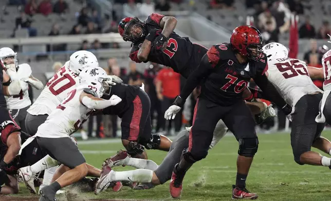 San Diego State running back Marquez Cooper leaps into the end zone for a touchdown during the second half of an NCAA college football game against Washington State Saturday, Oct. 26, 2024, in San Diego. (AP Photo/Gregory Bull)