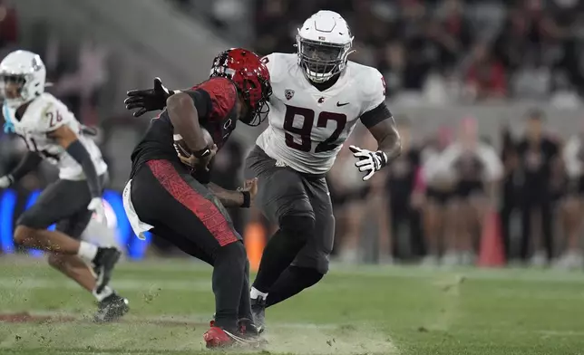 Washington State defensive lineman Ansel Din-Mbuh stops San Diego State quarterback Javance Tupou'ata-Johnson during the first half of an NCAA college football game Saturday, Oct. 26, 2024, in San Diego. (AP Photo/Gregory Bull)