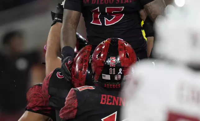 San Diego State running back Marquez Cooper, above, celebrates with teammates after scoring a touchdown during the first half of an NCAA college football game against Washington State Saturday, Oct. 26, 2024, in San Diego. (AP Photo/Gregory Bull)