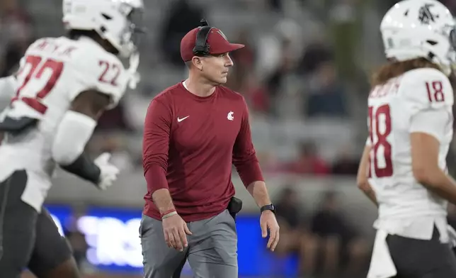 Washington State head coach Jake Dickert, center, looks on during the first half of an NCAA college football game against San Diego State Saturday, Oct. 26, 2024, in San Diego. (AP Photo/Gregory Bull)