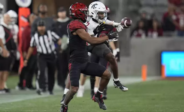 Washington State wide receiver Kyle Williams, right, makes a catch as San Diego State cornerback Chris Johnson defends during the second half of an NCAA college football game Saturday, Oct. 26, 2024, in San Diego. (AP Photo/Gregory Bull)