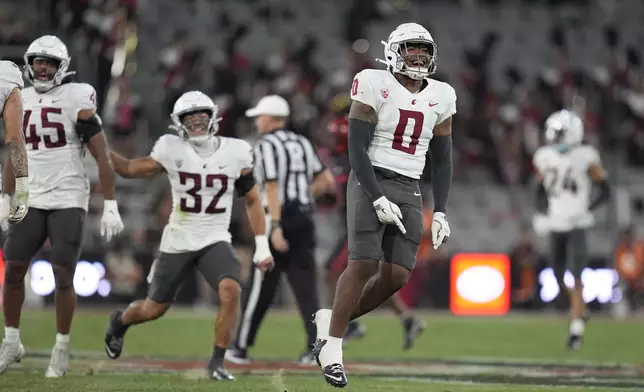 Washington State linebacker Taariq Al-Uqdah (0) celebrates with teammates after a fourth down stop during the first half of an NCAA college football game against San Diego State Saturday, Oct. 26, 2024, in San Diego. (AP Photo/Gregory Bull)