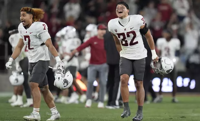 Washington State defensive back Tanner Moku (32) and defensive back Jackson Lataimua (2) celebrate during the second half of an NCAA college football game against San Diego State Saturday, Oct. 26, 2024, in San Diego. (AP Photo/Gregory Bull)