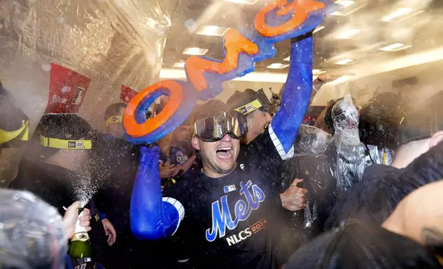 The New York Mets celebrate in the locker room after defeating the Philadelphia Phillies in Game 4 of the National League baseball playoff series, Wednesday, Oct. 9, 2024, in New York. (AP Photo/Frank Franklin II)