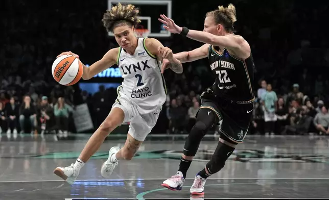 Minnesota Lynx's Natisha Hiedeman, left, dribbles against New York Liberty's Courtney Vandersloot, right, during the second half in Game 1 of a WNBA basketball final playoff series, Thursday, Oct. 10, 2024, in New York. (AP Photo/Pamela Smith)