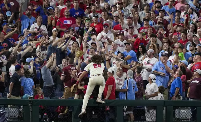 Philadelphia Phillies third base Alec Bohm chases a foul ball by New York Mets' Harrison Bader during the ninth inning of Game 2 of a baseball NL Division Series, Sunday, Oct. 6, 2024, in Philadelphia. (AP Photo/Matt Slocum)