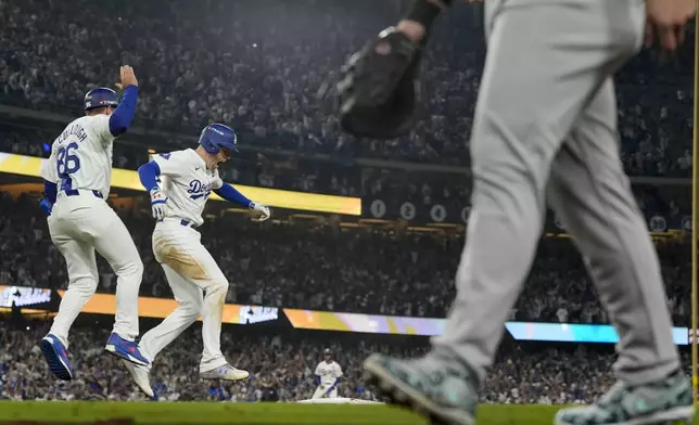 Los Angeles Dodgers' Freddie Freeman, middle, celebrates his walk-off grand slam home run against the New York Yankees during the 10th inning in Game 1 of the baseball World Series, Friday, Oct. 25, 2024, in Los Angeles. (AP Photo/Ashley Landis)