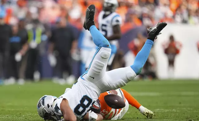 Denver Broncos safety Brandon Jones (22) tackles Carolina Panthers wide receiver Jalen Coker (18) during the second half of an NFL football game Sunday, Oct. 27, 2024, in Denver. (AP Photo/Jack Dempsey)