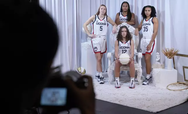 UConn basketball players Paige Bueckers, left, Ashlynn Shade, bottom center, Sarah Strong, top center, and Azzi Fudd pose for pictures during the Big East NCAA college basketball media day in New York, Wednesday, Oct. 23, 2024. (AP Photo/Seth Wenig)