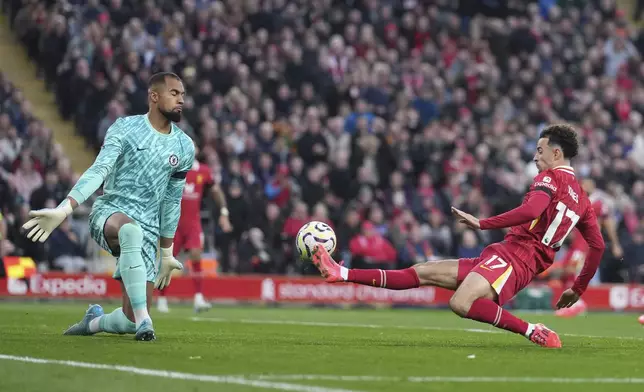 Liverpool's Curtis Jones, right, scores his side's second goal past Chelsea's goalkeeper Robert Sanchez during the English Premier League soccer match between Liverpool and Chelsea at Anfield Stadium, Liverpool, England, Sunday, Oct. 20, 2024. (AP Photo/Jon Super)