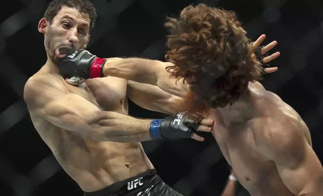 Shara Magomedov, right, punches Armen Petrosyan during a middleweight mixed martial arts bout at UFC Fight Night on Saturday, Oct. 26, 2024, in Abu Dhabi, United Arab Emirates. (AP Photo/Altaf Qadri)