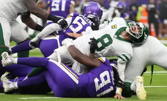 New York Jets quarterback Aaron Rodgers (8), right, reacts as he is tackled during the second half of an NFL football game against the Minnesota Vikings, Sunday, Oct. 6, 2024, at the Tottenham Hotspur stadium in London. (AP Photo/Kirsty Wigglesworth)