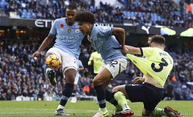 Southampton's Ryan Manning, right, duels for the ball with Manchester City's Rico Lewis, center, and Manchester City's Manuel Akanji during the English Premier League soccer match between Manchester City and Southampton at the Etihad Stadium in Manchester, England, Saturday, Oct. 26, 2024. (AP Photo/Darren Staples)