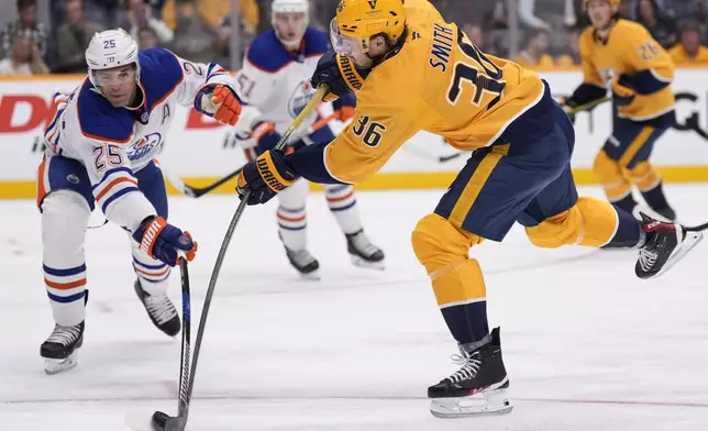 Nashville Predators left wing Cole Smith (36) shoots the puck past Edmonton Oilers defenseman Darnell Nurse (25) during the second period of an NHL hockey game Thursday, Oct. 17, 2024, in Nashville, Tenn. (AP Photo/George Walker IV)