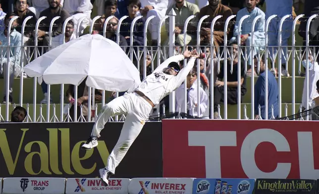 Pakistan's Saim Ayub jumps but fails to take a catch from a shot by England's Jamie Smith on the boundary edge during day one of the third test cricket match between Pakistan and England, in Rawalpindi, Pakistan, Thursday, Oct. 24, 2024. (AP Photo/Anjum Naveed)