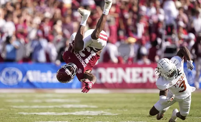 Oklahoma wide receiver J.J. Hester (13) is upended after catching a pass by Texas defensive back Jaylon Guilbeau (3) in the first half of an NCAA college football game in Dallas, Saturday, Oct. 12, 2024. (AP Photo/Tony Gutierrez)