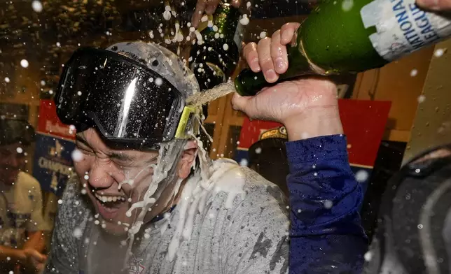 Los Angeles Dodgers Shohei Ohtani celebrates in the locker room after their win against the New York Mets in Game 6 of a baseball NL Championship Series, Sunday, Oct. 20, 2024, in Los Angeles. (AP Photo/Ashley Landis)