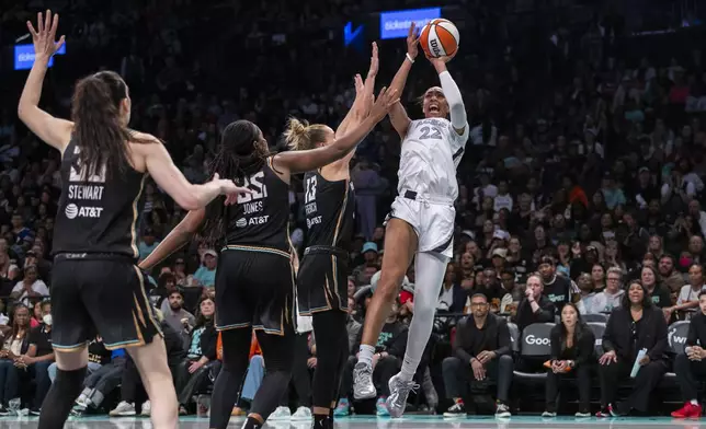 Las Vegas Aces center A'ja Wilson (22) shoots over New York Liberty forward Leonie Fiebich (13) as forward Breanna Stewart (30) and forward Jonquel Jones (35) defend during the second half of a WNBA basketball second-round playoff game, Sunday, Sept. 29, 2024, in New York. (AP Photo/Corey Sipkin)