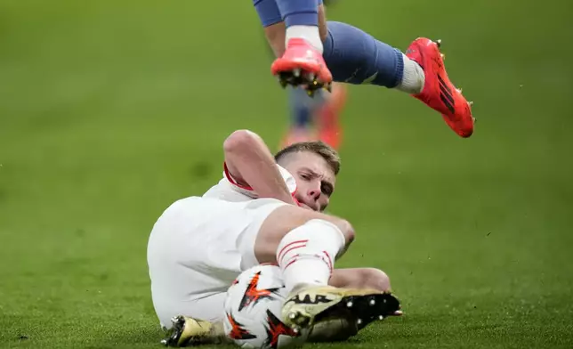 Ajax's Mika Godts jumps over Slavia's David Doudera during the Europa League soccer match between Slavia and Ajax at the Eden Arena, in Prague, Czech Republic, Thursday, Oct. 3, 2024. (AP Photo/Petr David Josek)