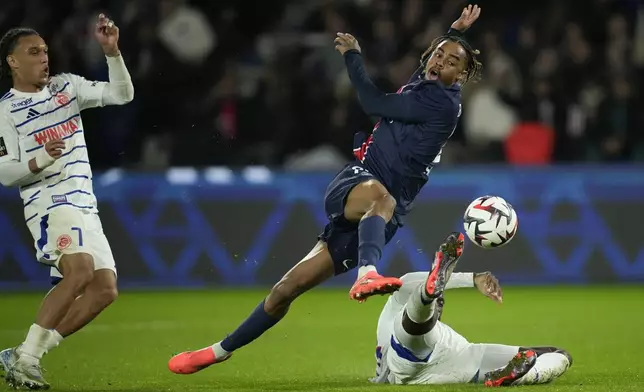 PSG's Bradley Barcola, center, gets in a shot during the French League One soccer match between Paris Saint-Germain and Strasbourg at the Parc des Princes in Paris, Saturday, Oct. 19, 2024. (AP Photo/Christophe Ena)