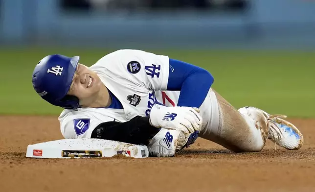 Los Angeles Dodgers' Shohei Ohtani holds his arm after being injured while trying to steal second base during the seventh inning in Game 2 of the baseball World Series against the New York Yankees, Saturday, Oct. 26, 2024, in Los Angeles. (AP Photo/Godofredo A. Vásquez)