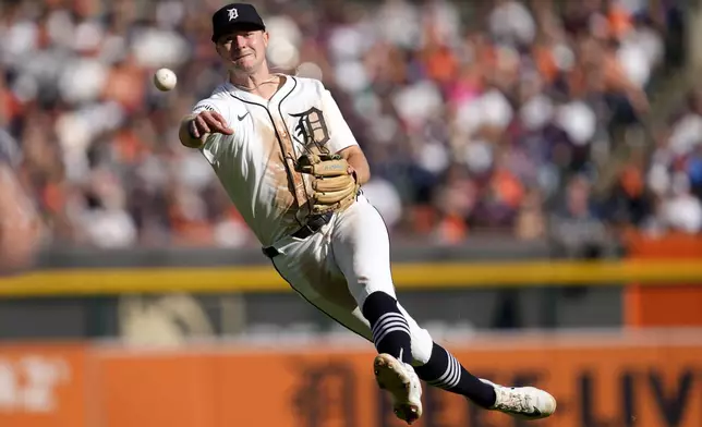 Detroit Tigers shortstop Trey Sweeney throws errantly to first base on a single by Cleveland Guardians' Steven Kwan in the third inning during Game 3 of a baseball American League Division Series, Wednesday, Oct. 9, 2024, in Detroit. (AP Photo/Paul Sancya)