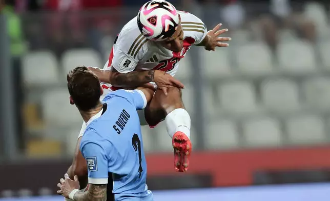 Peru's Alex Valera, top, and Uruguay's Santiago Bueno battle for the ball during a qualifying soccer match for the FIFA World Cup 2026 at National Stadium in Lima, Peru, Friday, Oct. 11, 2024. (AP Photo/Daniel Apuy)