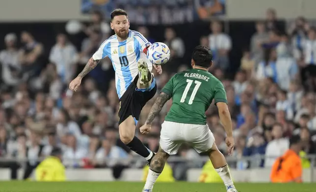 Argentina's Lionel Messi jumps for the ball challenged by Bolivia's Carmelo Algaranaz during a World Cup 2026 qualifying soccer match at Monumental stadium in Buenos Aires, Argentina, Tuesday, Oct. 15, 2024. (AP Photo/Natacha Pisarenko)