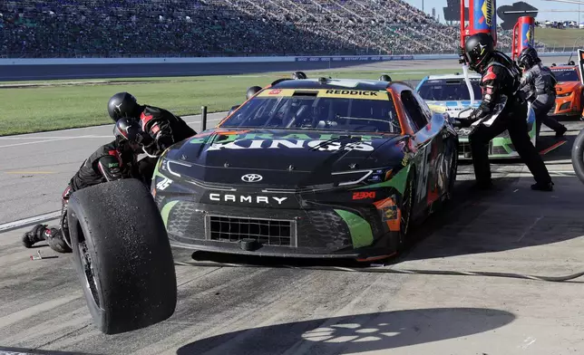 Tyler Reddick (45) has his tires changed on pit road during a NASCAR Cup Series auto race at Kansas Speedway in Kansas City, Kan., Sunday, Sept. 29, 2024. (AP Photo/Colin E. Braley)