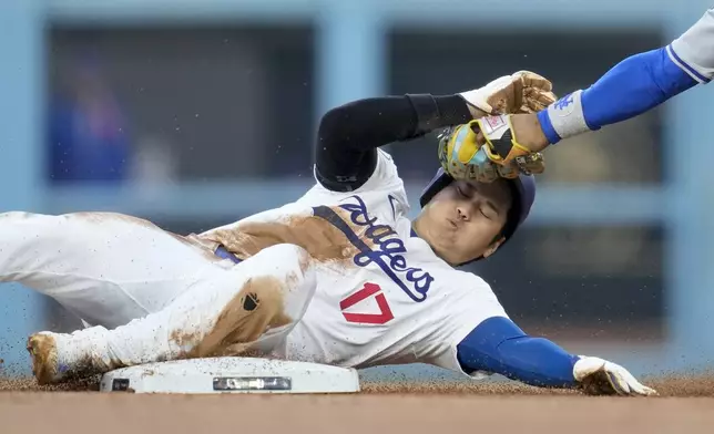 Los Angeles Dodgers' Shohei Ohtani gets caught stealing by New York Mets shortstop Francisco Lindor during the second inning in Game 1 of a baseball NL Championship Series, Sunday, Oct. 13, 2024, in Los Angeles. (AP Photo/Ashley Landis)