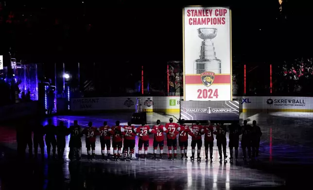 The Florida Panthers raise their Stanley Cup championship banner before the start of the NHL hockey game against the Boston Bruins, Tuesday, Oct. 8, 2024, in Sunrise, Fla. (AP Photo/Jim Rassol)