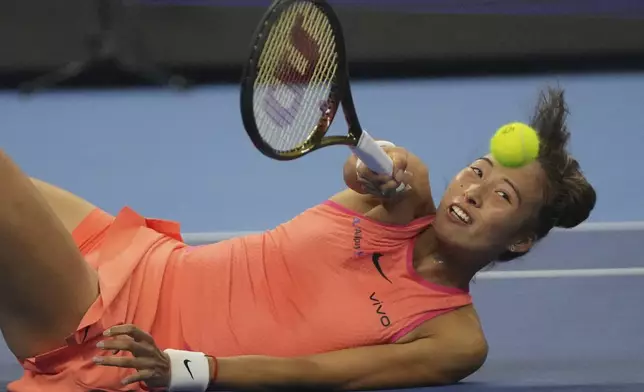 Zheng Qinwen of China returns a shot to Karolina Muchova of the Czech Republic in a women's singles semi-final match, of the China Open tennis tournament, at the National Tennis Center in Beijing, Saturday, Oct. 5, 2024. (AP Photo/Achmad Ibrahim)