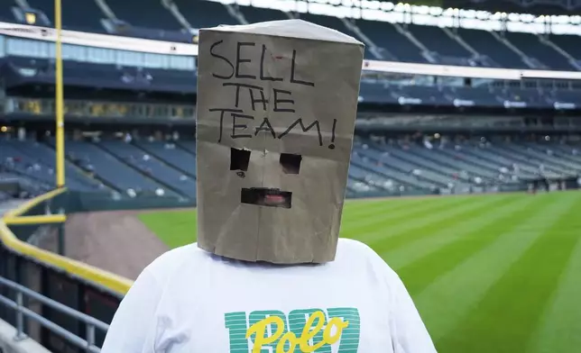 Christian Landreth from Glen Ellyn Illinois wears a bag on his head before a baseball game between the Chicago White Sox and the Los Angeles Angels. The White Sox are going for the MLB record for loses122 if they lose tonight, Wednesday, Sept. 25, 2024, in Chicago. (AP Photo/David Banks)