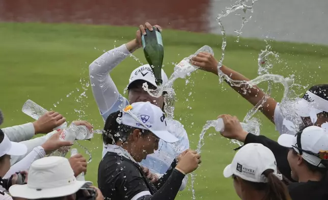 Fellow golfers sprinkle water on Ruoning Yin of China after she wins the final round of the LPGA Shanghai at China's Shanghai Qizhong Garden Golf Club, Sunday, Oct. 13, 2024. (AP Photo/Achmad Ibrahim)