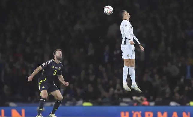 Portugal's Cristiano Ronaldo, right, heads the ball ahead of Scotland's Grant Hanley during the UEFA Nations League soccer match between Scotland and Portugal at Hampden Park in Glasgow, Scotland, Tuesday, Oct. 15, 2024. (AP Photo/Scott Heppell)